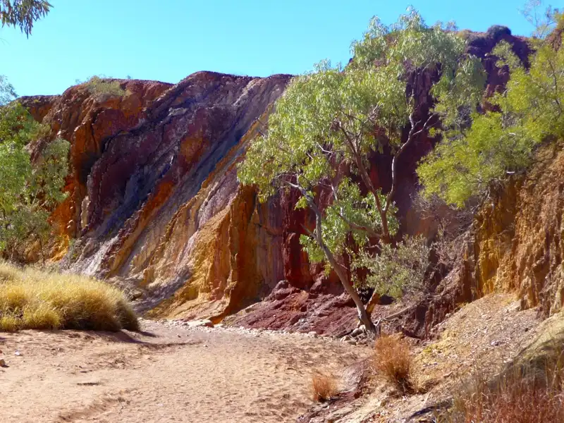 Ochre Pits in the West MacDonnell Ranges with colourful layers of red, yellow, and white ochre cliffs in an ancient desert setting.