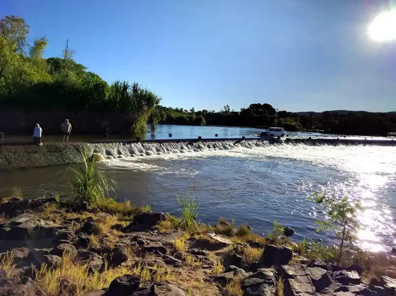 Ivanhoe Crossing over the Ord River near Kununurra, with a low concrete causeway spanning the wide river and surrounding Kimberley landscape.