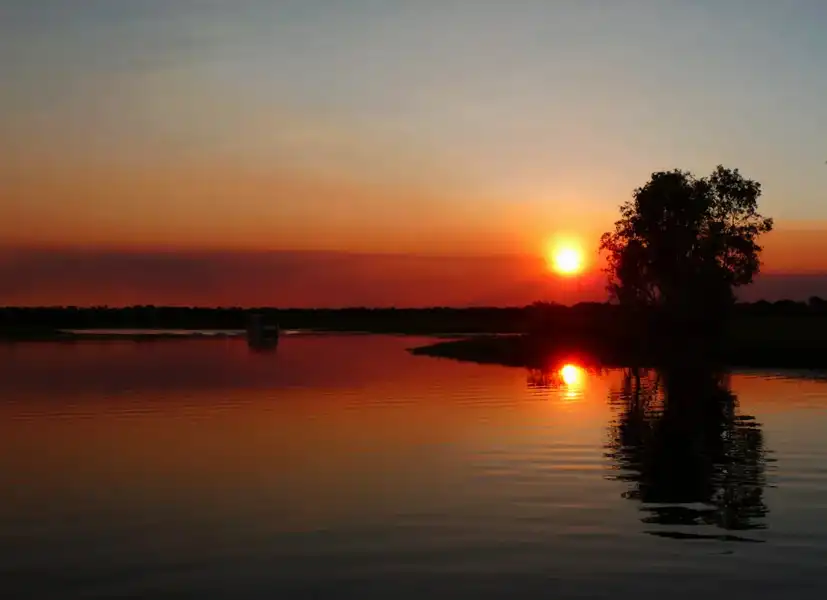 Sunset colours reflecting on the calm waters of Yellow Water Billabong at dusk.