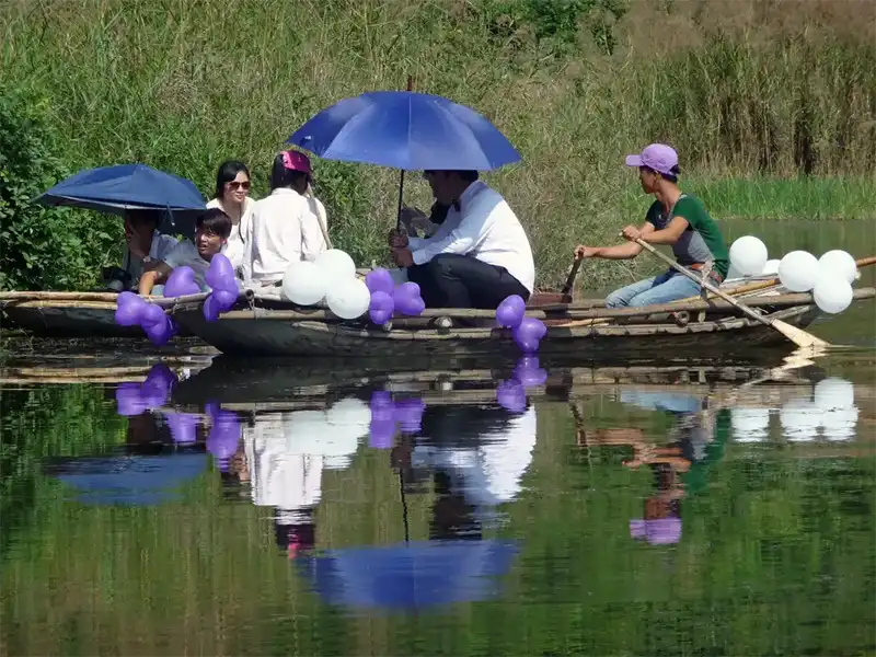 Boat carrying a newlywed couple gliding through calm waters Ninh Binh, Vietnam