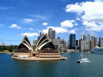 Sailing boat passing the Sydney Opera House on Sydney Harbour, Australia.