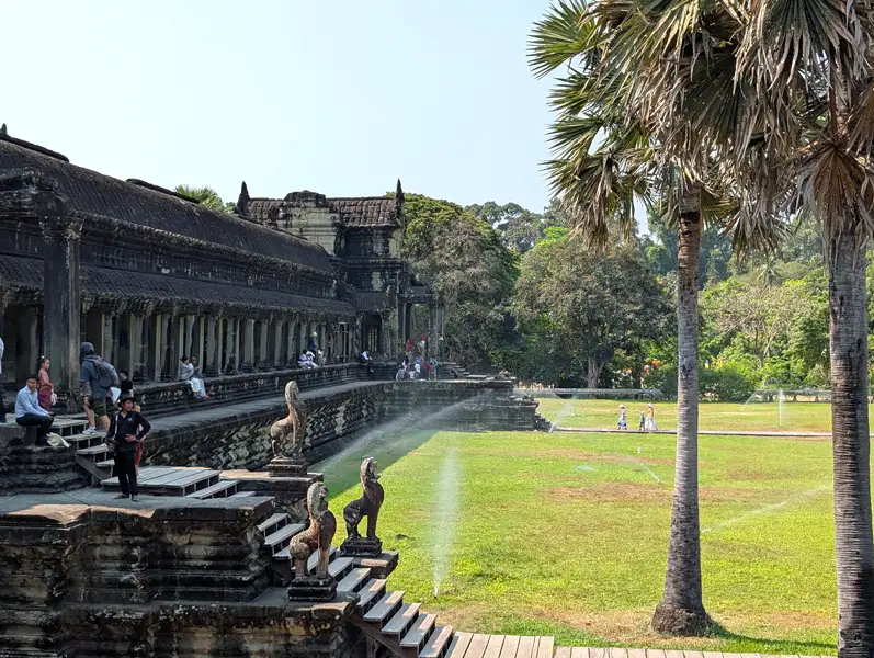 People sicking shade at ancient temple walls, Angkor Wat, Siem Reap